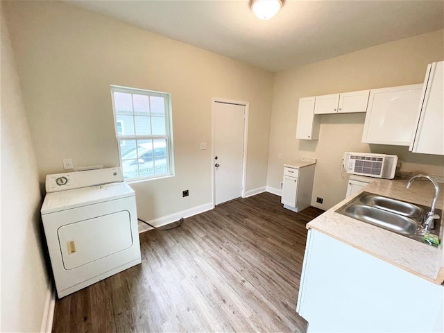 kitchen with washer / clothes dryer, sink, white cabinets, and hardwood / wood-style flooring