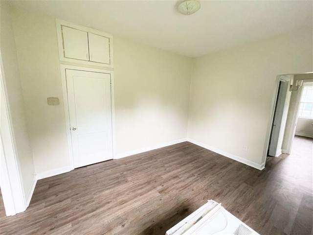 unfurnished room with dark wood-type flooring