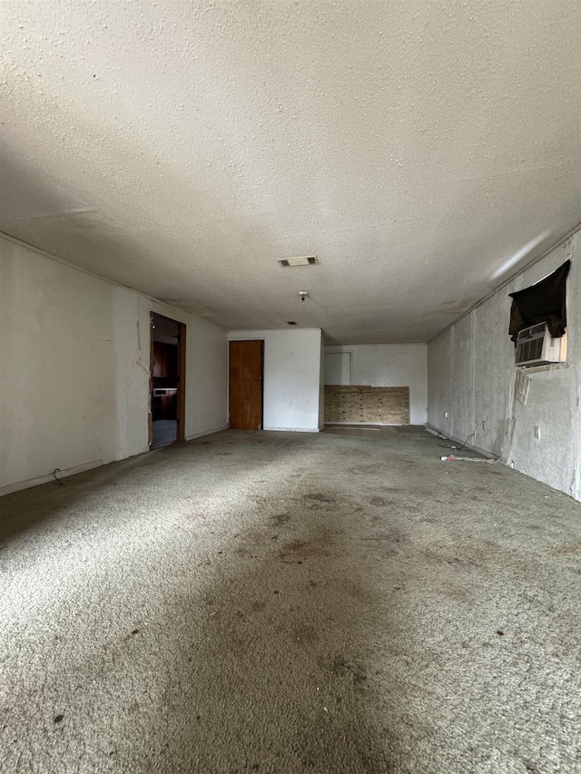 unfurnished living room with cooling unit and a textured ceiling