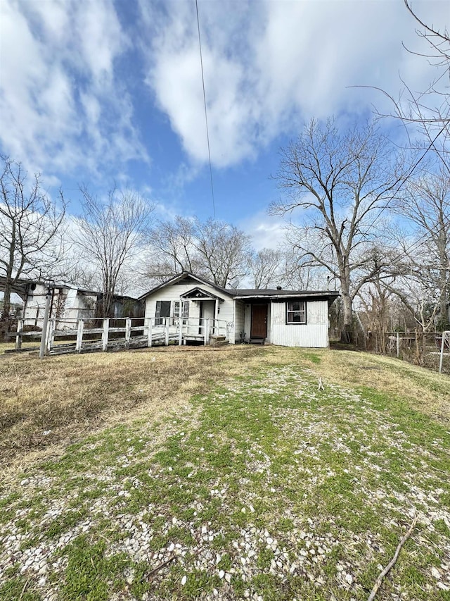 rear view of property featuring a lawn