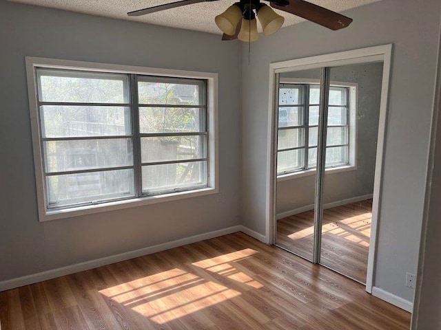 unfurnished room with light wood-type flooring and a textured ceiling