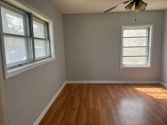 spare room with ceiling fan, wood-type flooring, and a textured ceiling