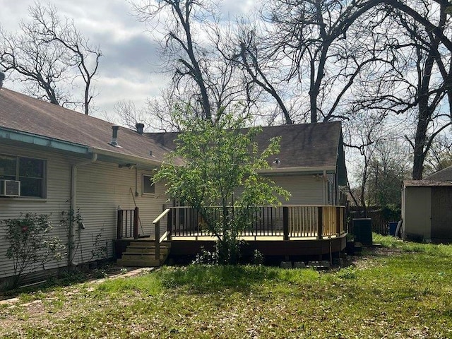 rear view of property with a deck, cooling unit, and a lawn