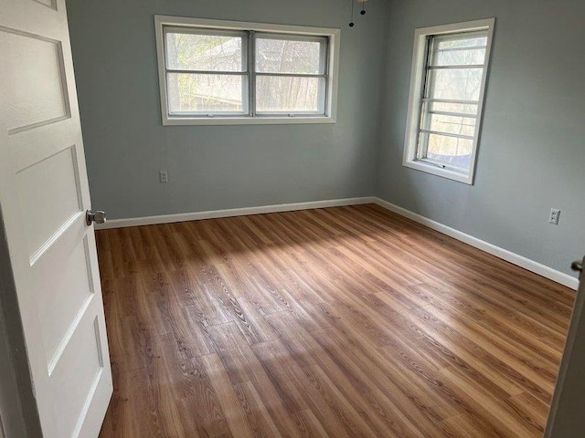 unfurnished room with hardwood / wood-style flooring and a healthy amount of sunlight