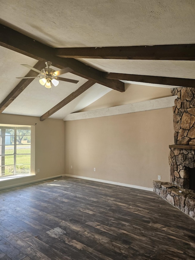 unfurnished living room with lofted ceiling with beams, dark hardwood / wood-style floors, ceiling fan, a textured ceiling, and a fireplace