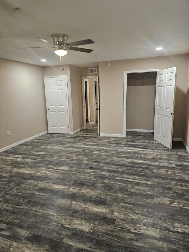 unfurnished bedroom with dark hardwood / wood-style flooring, a closet, and ceiling fan