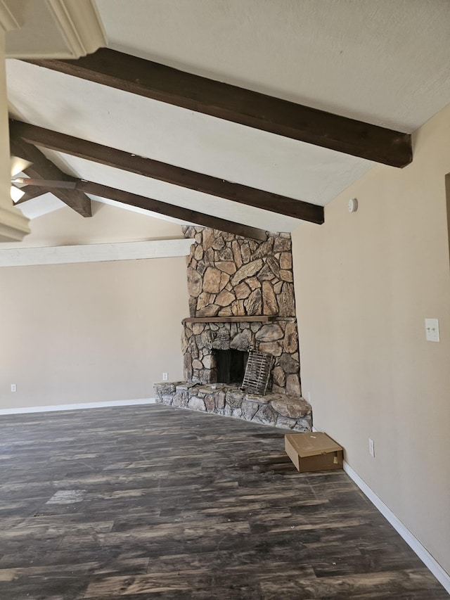 unfurnished living room with vaulted ceiling with beams, dark hardwood / wood-style floors, and a stone fireplace