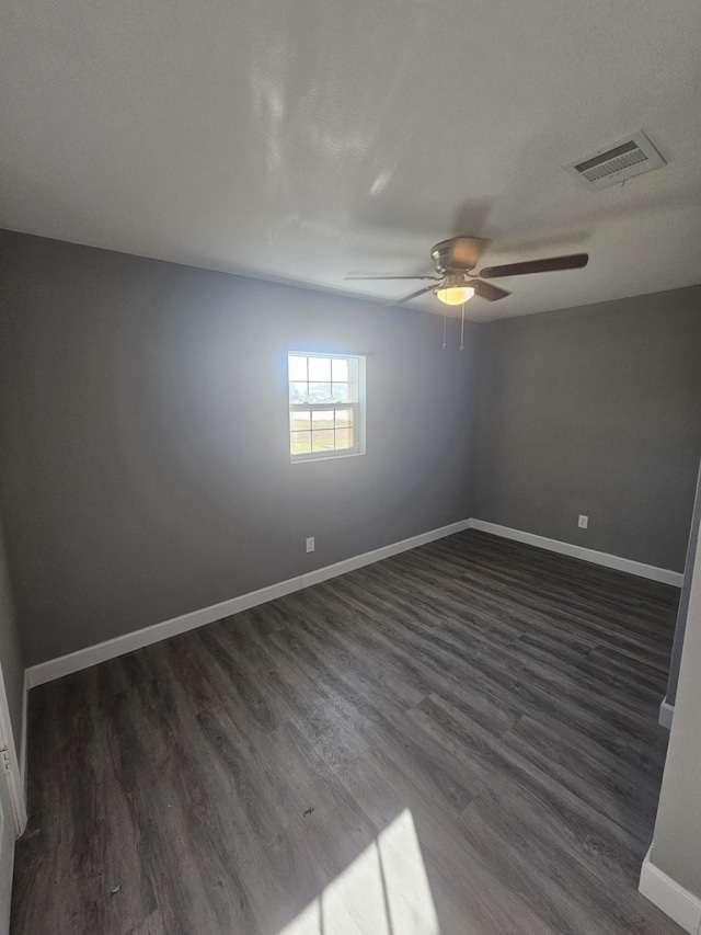 spare room featuring dark hardwood / wood-style flooring and ceiling fan