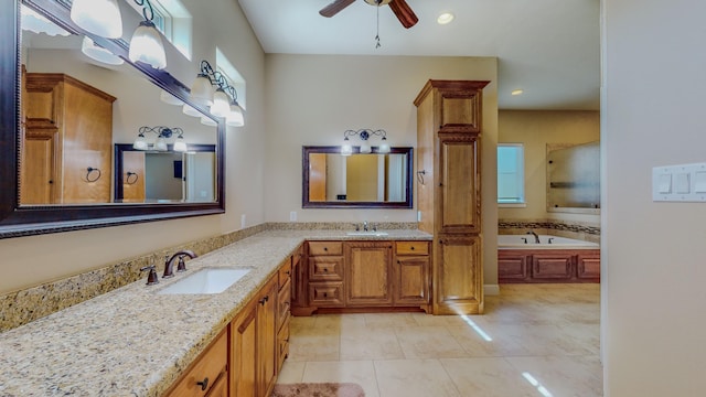 bathroom with ceiling fan, a washtub, vanity, and tile patterned flooring