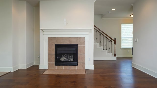 2650 Cedar Spgs, Port Arthur, TX 77640 - unfurnished living room featuring stairway, wood finished floors, a tiled fireplace, baseboards, and ornamental molding
