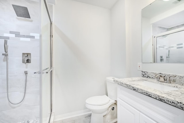 bathroom with vanity, toilet, and a shower with door