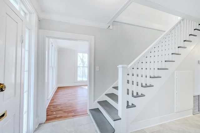 stairway featuring tile patterned floors and ornamental molding