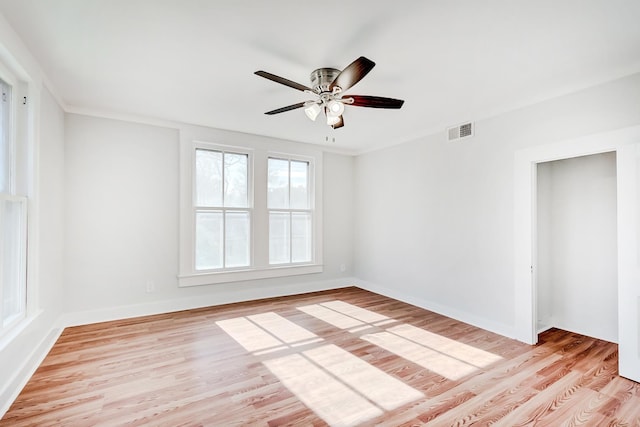 empty room with ceiling fan, crown molding, and light wood-type flooring