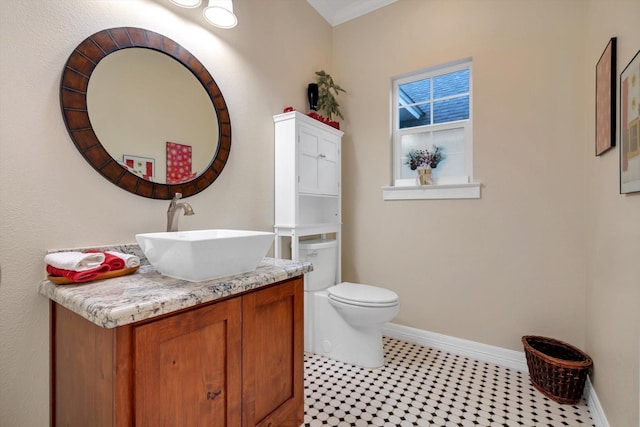 bathroom featuring tile patterned flooring, vanity, toilet, and crown molding