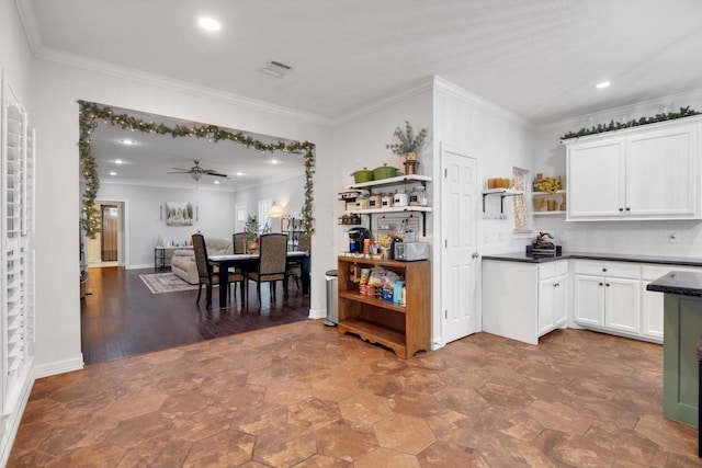 kitchen featuring decorative backsplash, white cabinetry, crown molding, and ceiling fan