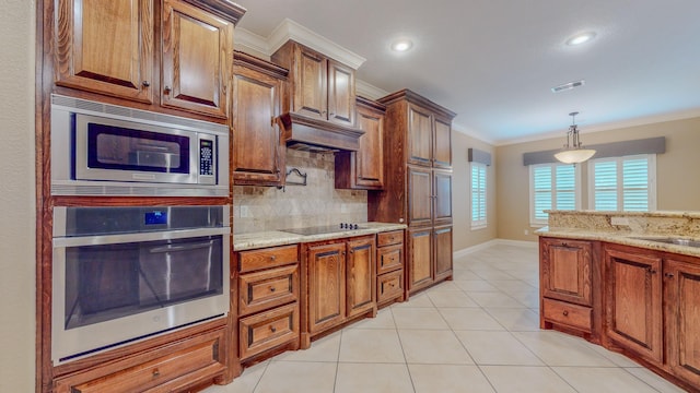 kitchen featuring hanging light fixtures, tasteful backsplash, light stone counters, appliances with stainless steel finishes, and ornamental molding