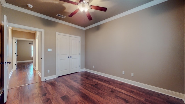 unfurnished bedroom featuring ceiling fan, dark hardwood / wood-style floors, ornamental molding, and a closet