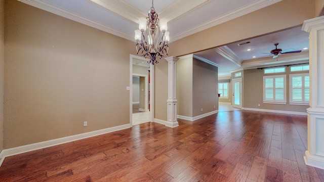 unfurnished room with ceiling fan with notable chandelier, a raised ceiling, ornamental molding, and ornate columns