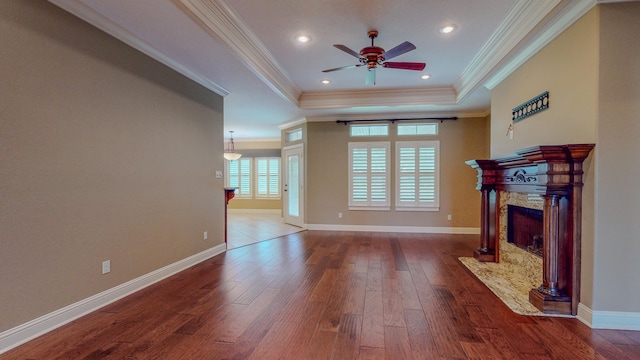 living room with a raised ceiling, ceiling fan, a high end fireplace, and ornamental molding