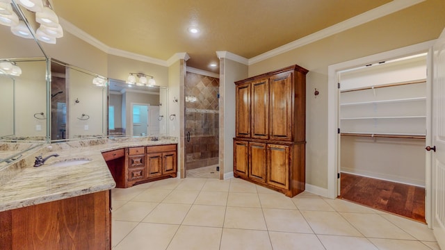 bathroom with tile patterned floors, crown molding, vanity, and a shower with shower door