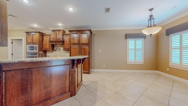 kitchen with light stone countertops, hanging light fixtures, stainless steel appliances, and ornamental molding