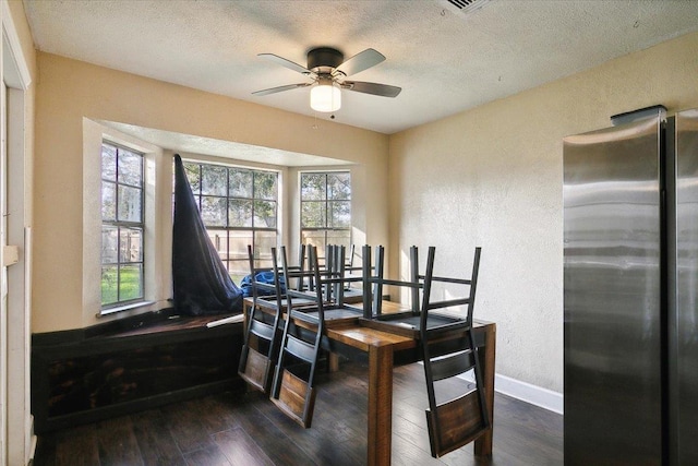 dining room with ceiling fan, dark hardwood / wood-style flooring, and a textured ceiling