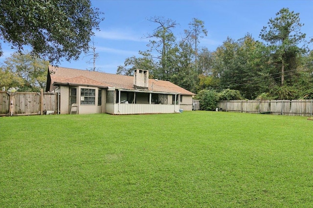 rear view of house with a lawn and a sunroom