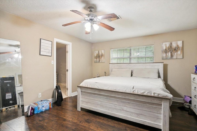 bedroom featuring ceiling fan, dark wood-type flooring, and a textured ceiling