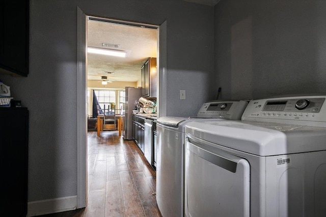 laundry room featuring washer and dryer, wood-type flooring, a textured ceiling, and ceiling fan