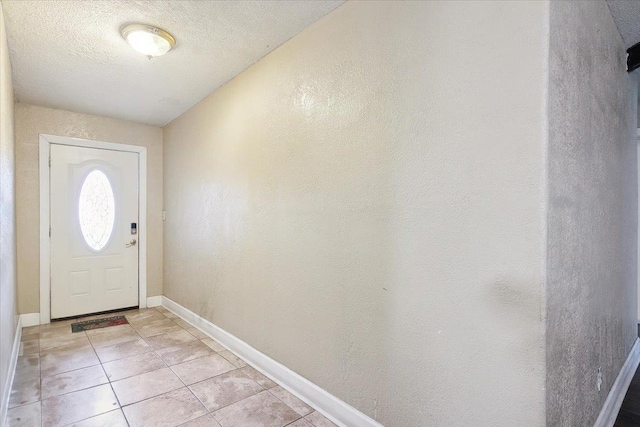 entryway with light tile patterned floors and a textured ceiling