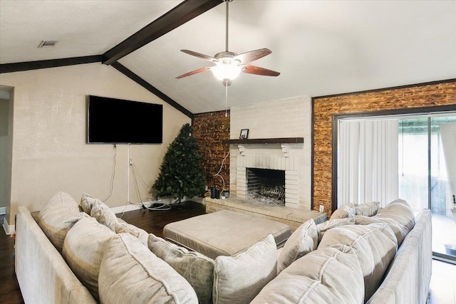 living room with vaulted ceiling with beams, dark hardwood / wood-style flooring, a brick fireplace, and ceiling fan