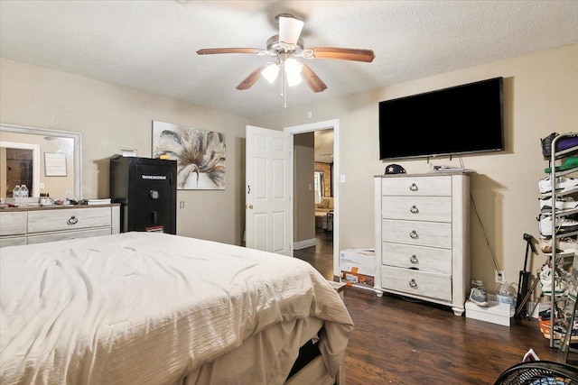 bedroom with a textured ceiling, ceiling fan, and dark wood-type flooring