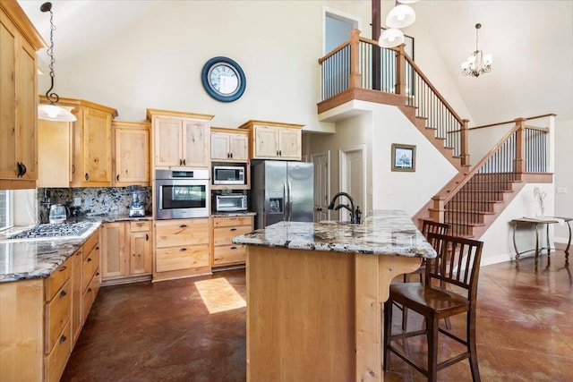 kitchen featuring tasteful backsplash, a center island, hanging light fixtures, and appliances with stainless steel finishes