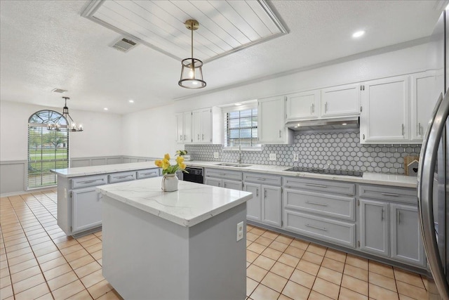 6635 Griffing Rd, Beaumont, TX 77708 - kitchen featuring under cabinet range hood, a kitchen island, a sink, visible vents, and black appliances