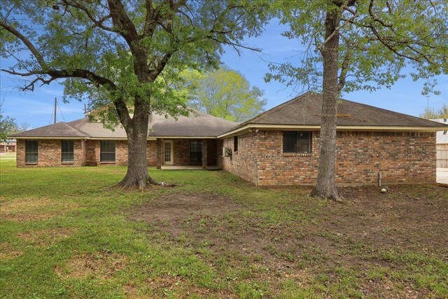 6635 Griffing Rd, Beaumont, TX 77708 - back of house with a lawn, brick siding, and a patio area