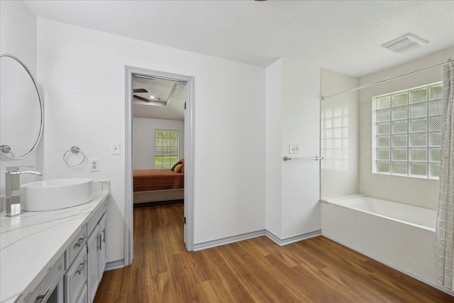 6635 Griffing Rd, Beaumont, TX 77708 - bathroom with wood finished floors, vanity, a textured ceiling, and visible vents