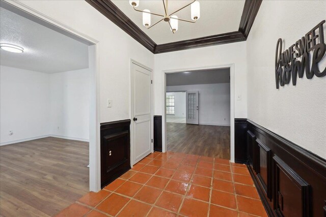 6635 Griffing Rd, Beaumont, TX 77708 - hall featuring a notable chandelier, crown molding, wood finished floors, and wainscoting