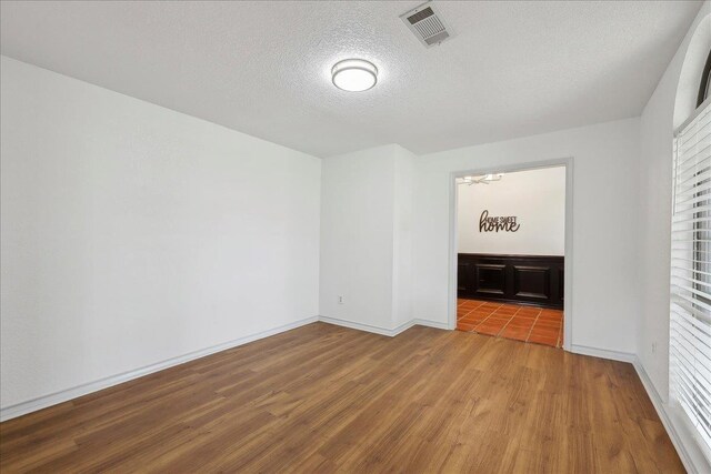6635 Griffing Rd, Beaumont, TX 77708 - unfurnished room featuring wood finished floors, a notable chandelier, a textured ceiling, and visible vents