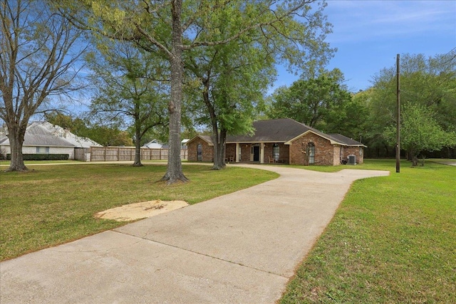 6635 Griffing Rd, Beaumont, TX 77708 - view of front of home with driveway, brick siding, fence, and a front lawn