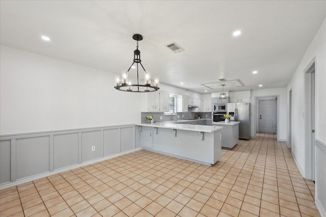 6635 Griffing Rd, Beaumont, TX 77708 - kitchen with light countertops, stainless steel appliances, a sink, visible vents, and a peninsula