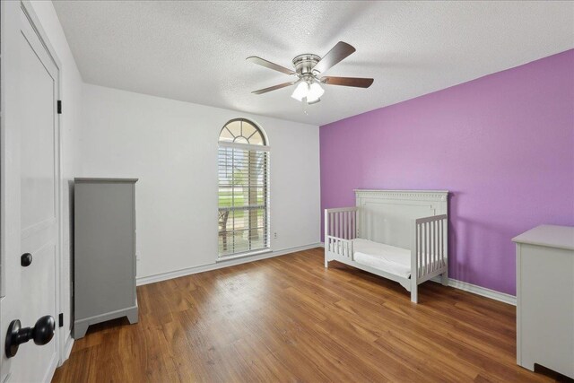 6635 Griffing Rd, Beaumont, TX 77708 - bedroom featuring baseboards, a textured ceiling, wood finished floors, and a ceiling fan