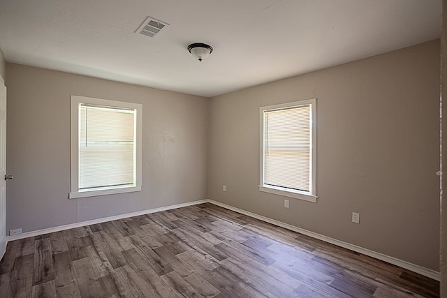 empty room with a healthy amount of sunlight and light hardwood / wood-style floors