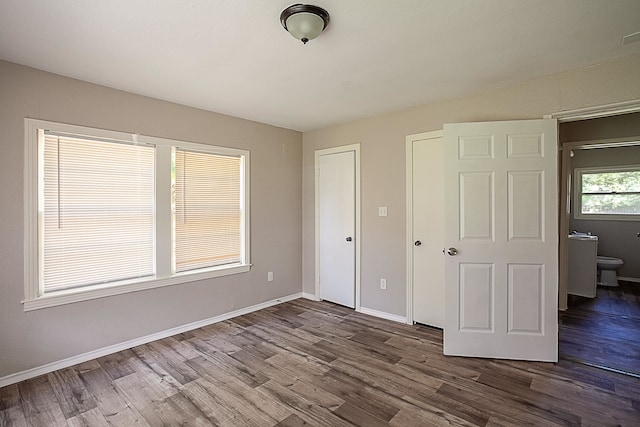 unfurnished bedroom featuring hardwood / wood-style floors and ensuite bathroom