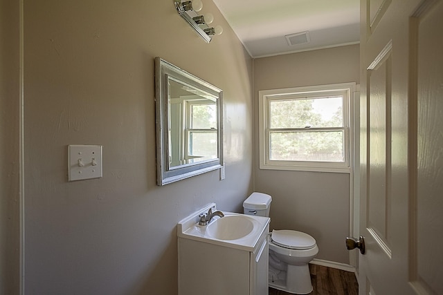 bathroom with hardwood / wood-style floors, vanity, and toilet