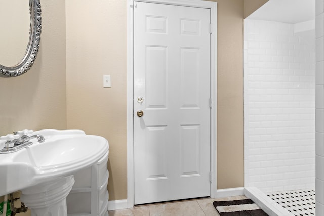 bathroom with tile patterned floors, a shower, and sink