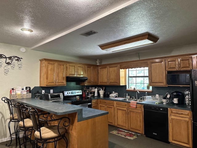 304 County Road 773, Buna, TX 77612 - kitchen featuring black appliances, under cabinet range hood, a textured ceiling, a sink, and dark countertops