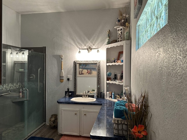304 County Road 773, Buna, TX 77612 - full bathroom featuring a textured wall, a stall shower, vanity, and wood finished floors