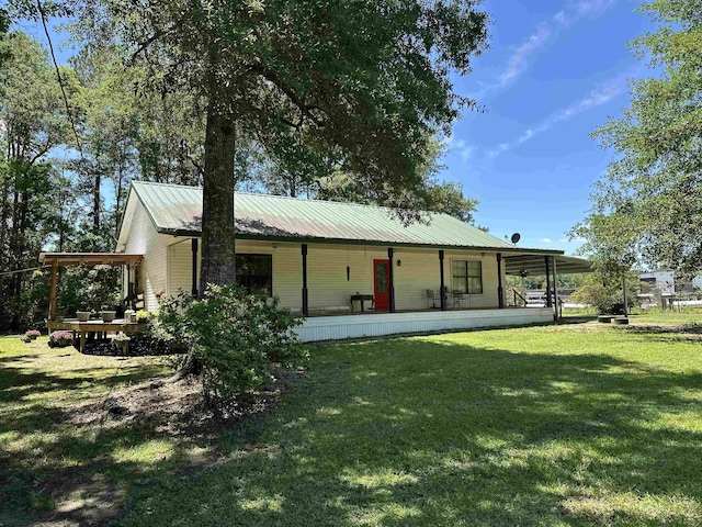 304 County Road 773, Buna, TX 77612 - back of house with covered porch, a yard, and metal roof
