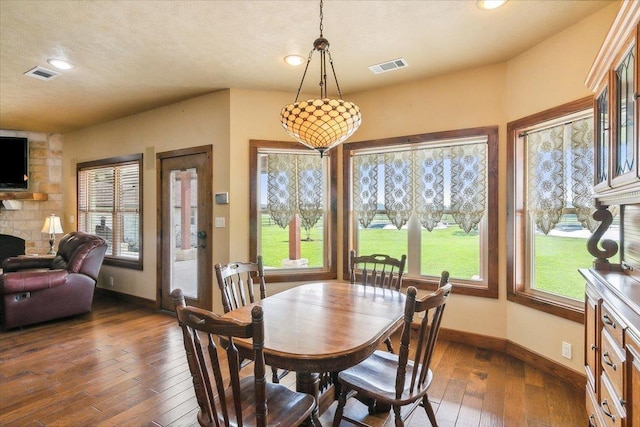 dining space featuring dark hardwood / wood-style floors and a fireplace