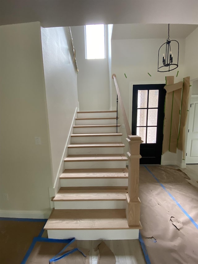 stairs with a chandelier